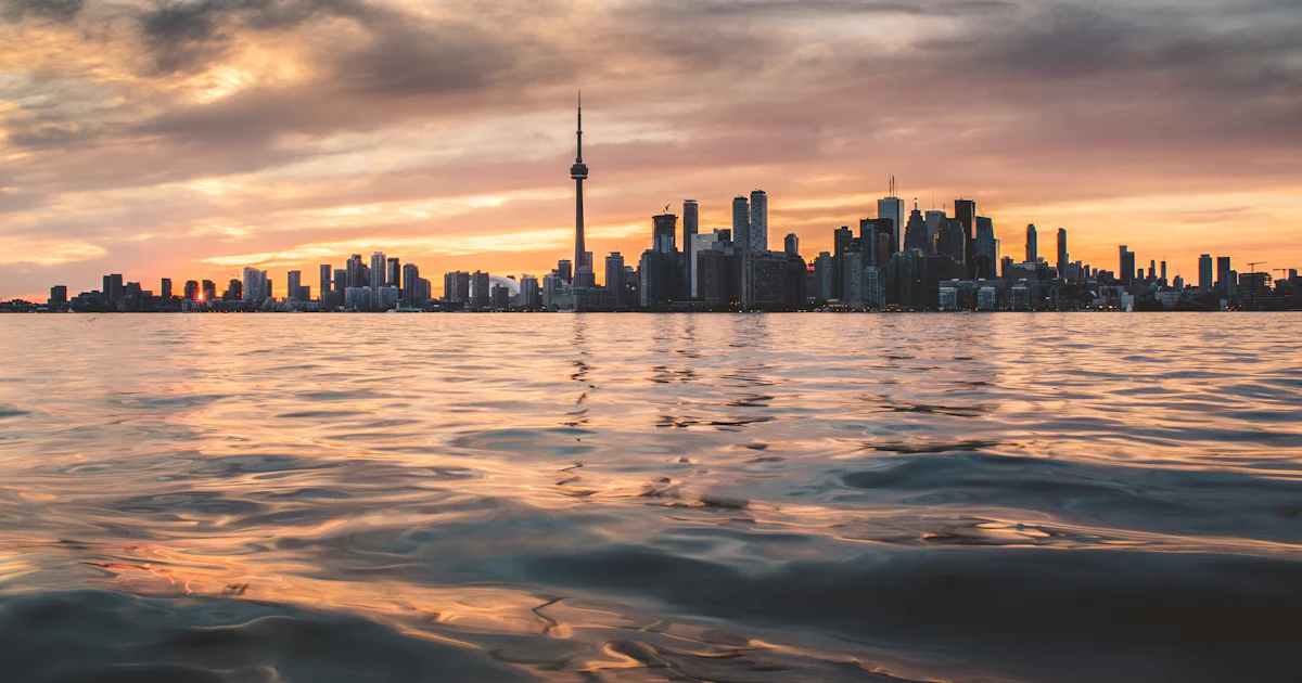 The Toronto skyline and CN Tower at sunset seen across Lake Ontario